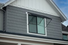 two-panel Bahama Awning by Goldberg Brothers on upper-floor window of new house