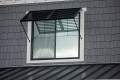 two-panel Bahama Awning by Goldberg Brothers on upper-floor window of new house