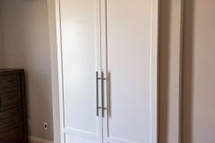 Hidden roller hardware on a custom-made biparting pair of white bathroom doors